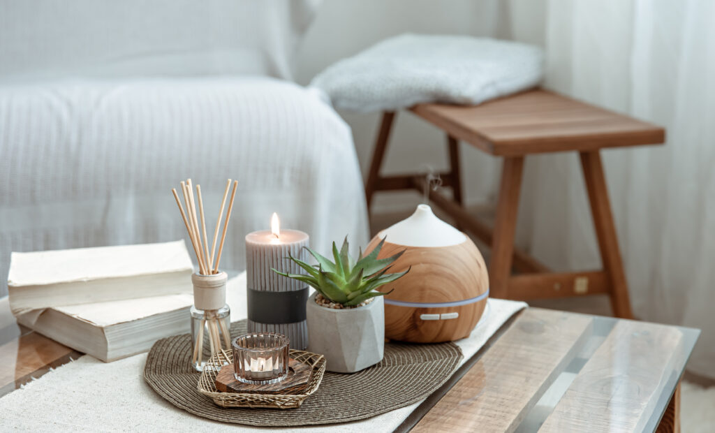 composition-with-incense-sticks-diffuser-candles-books-table-interior-room-scaled